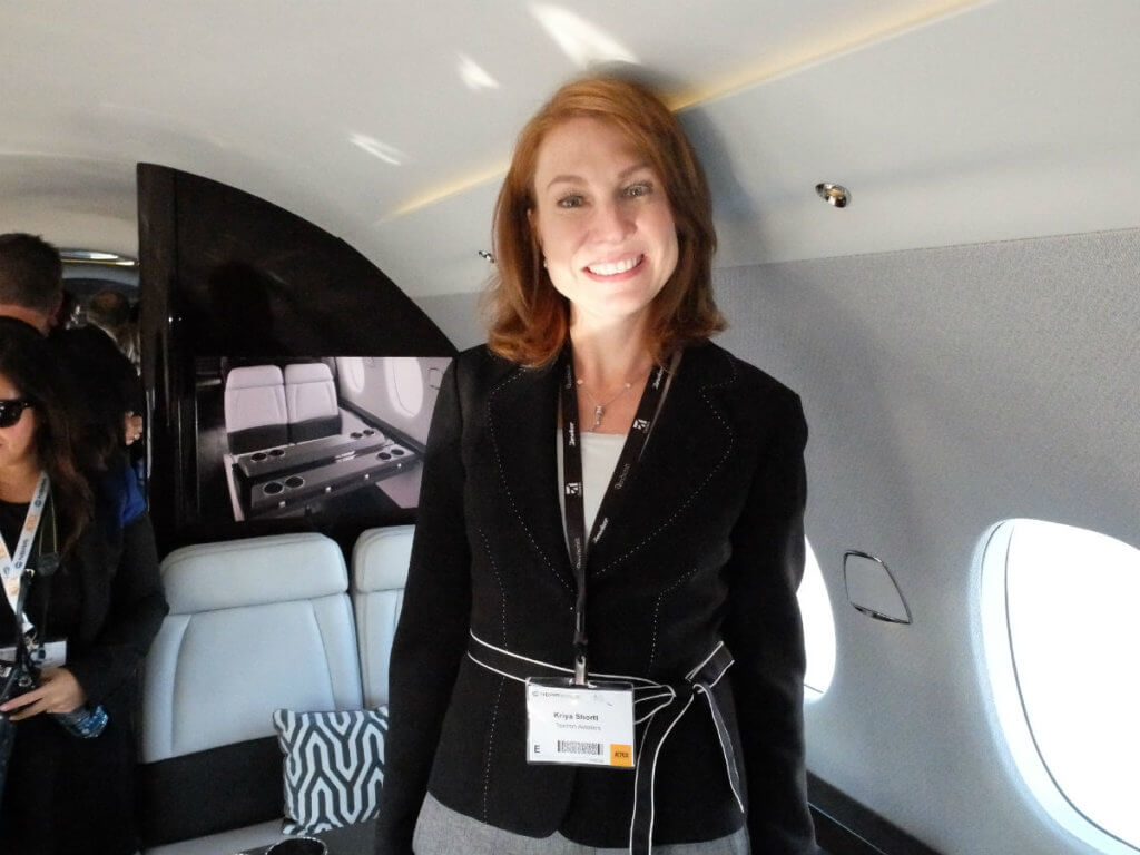 Kriya Shortt, Textron Aviation's vice-president of sales and marketing, shows off the 30-inch wide seats inside the Citaiton Hemipshere cabin mock-up at NBAA. Lisa Gordon Photo