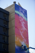 Michael Ortiz and Jonathan Lamb, of Like Minded Productions, paint the side of the Fletcher Gardens Apartments on Friday. Photo by Gabriel Christus/Aurora Sentinel