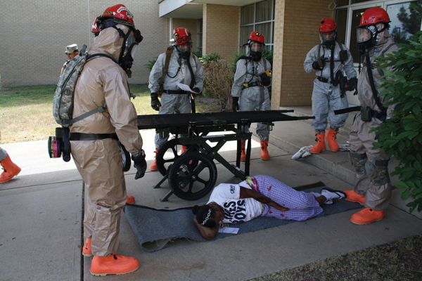 Adrienne Carter awaits aid during a National Guard exercise held at the Community College of Aurora Lowry campus June 9. Carter, a member of the National Guard, was one of 200 participants in a simulation exercise designed to train soldiers for large-scale emergencies.