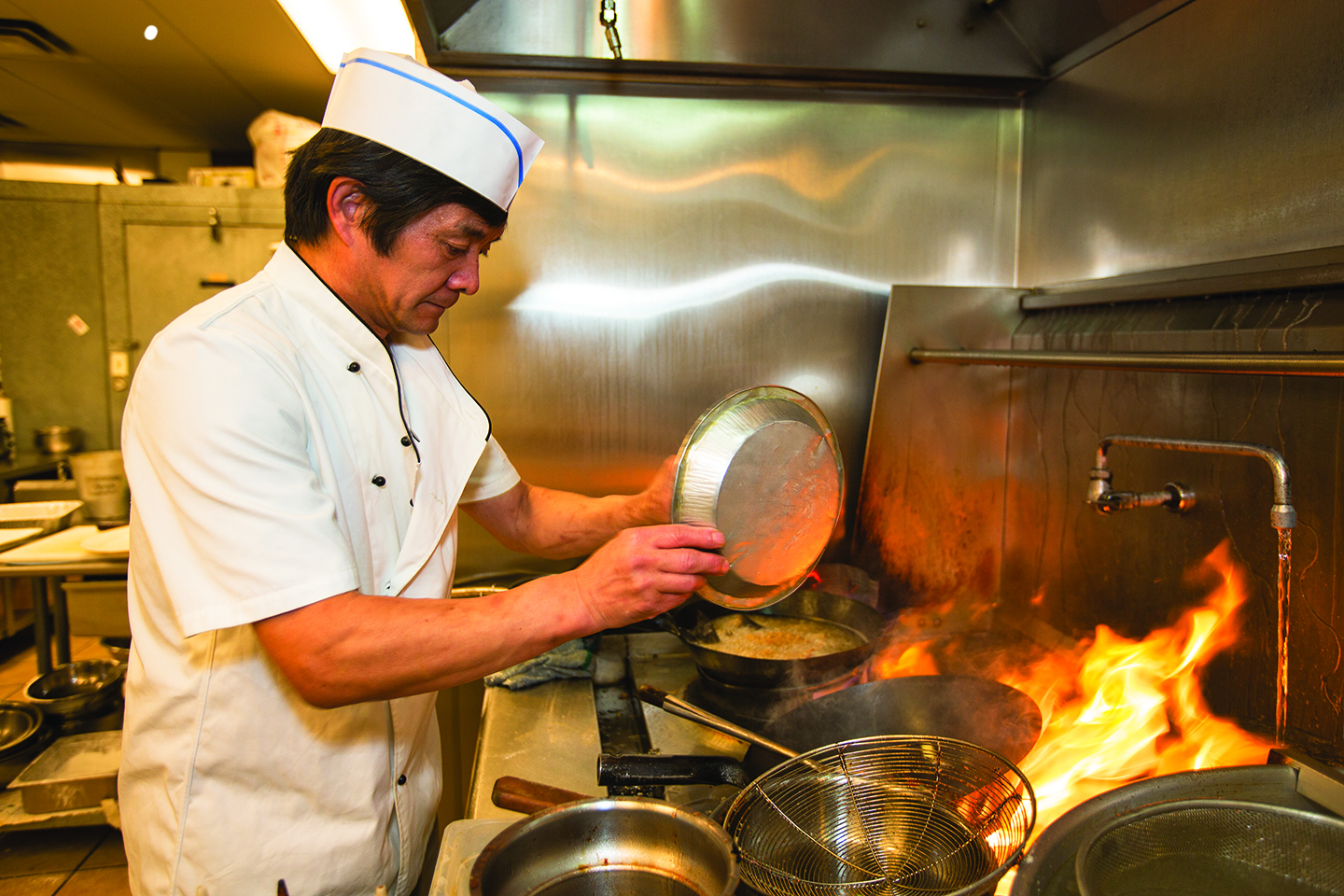 Chef Zeng Qun Liu prepares fried striped bass with tomato sauce at Chef Liu's Authentic Chinese Cuisine in Aurora. The restaurant is featured in Visit Aurora's inaugural Aurora Eats & Drinks poll. (Marla R. Keown/Aurora Sentinel)