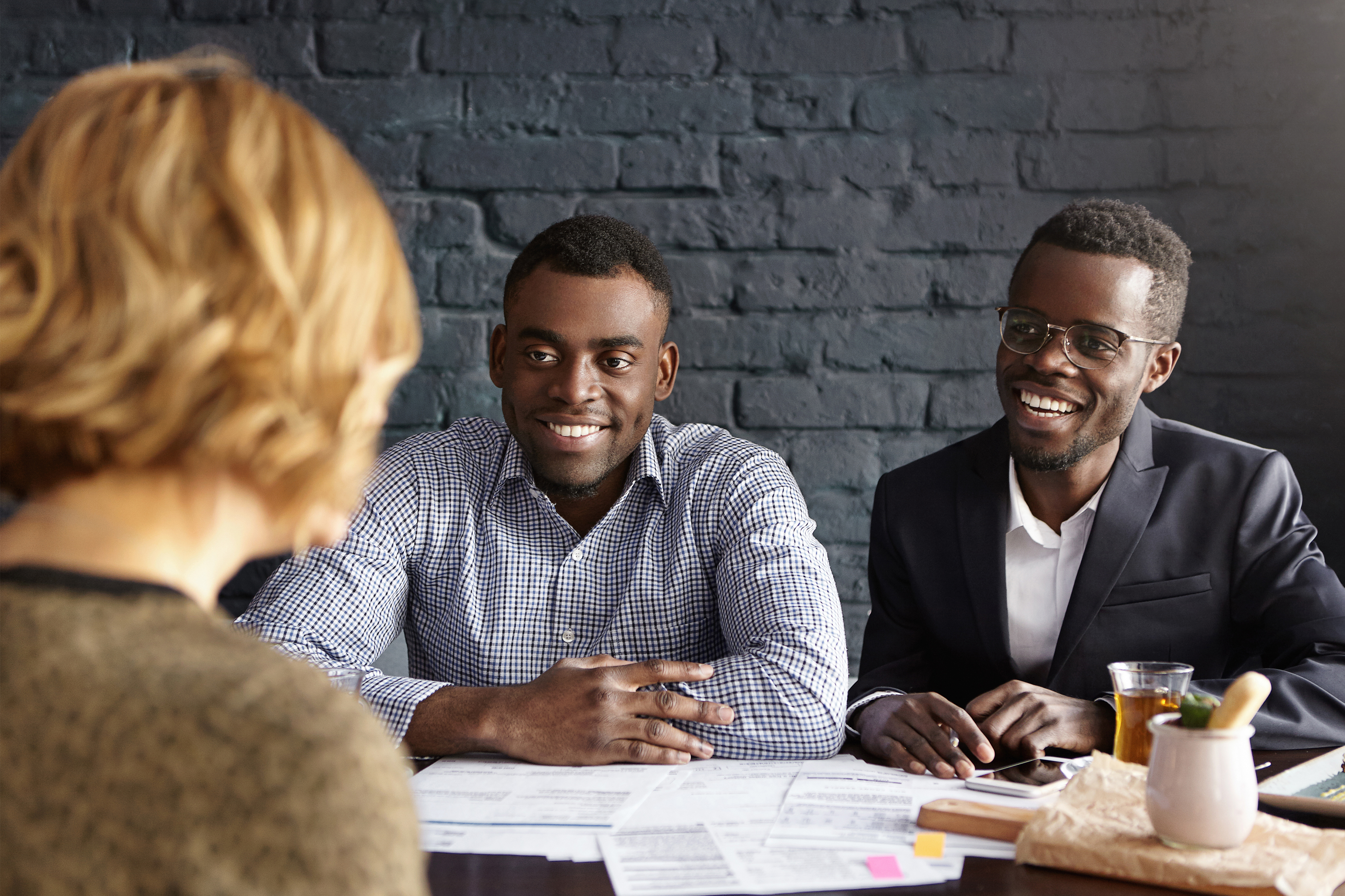 two young men sitting at table smiling