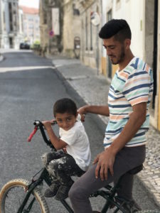 Father and son race their back up and down the street.