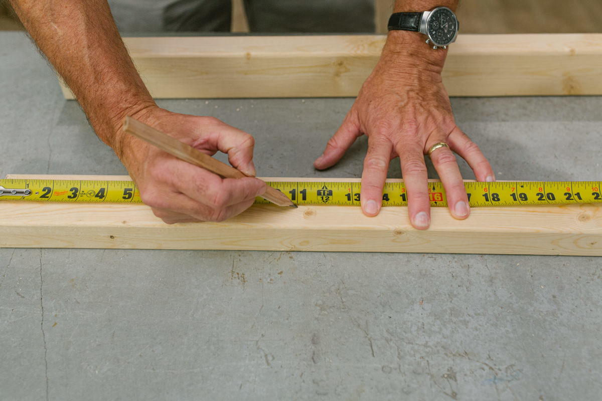 Measuring and marking board with measuring tape and pencil.