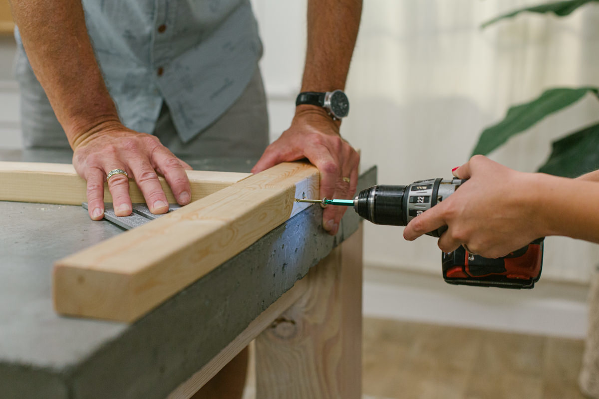 Drilling to attach two boards at right angle to create DIY wooden mini trebuchet side assembly.