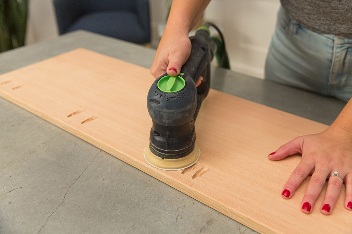 Sanding cut boards with power sander.