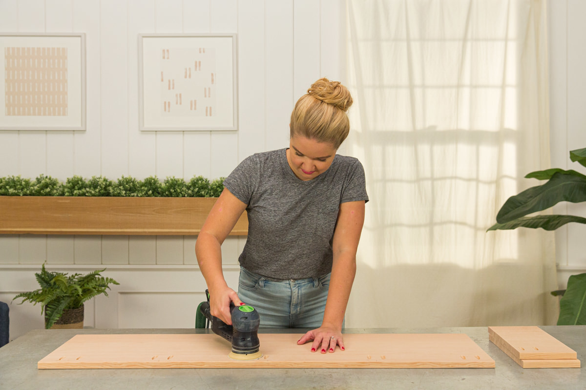 Sanding cut boards with power sander.