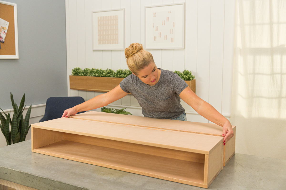 Lining up open rectangle of wood DIY coffee table assembly with open end of rectangle with back board.