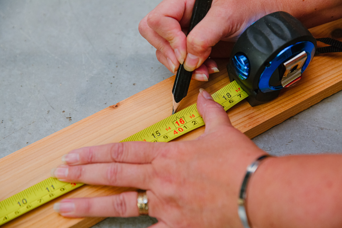 Measuring and marking board with measuring tape and pencil.