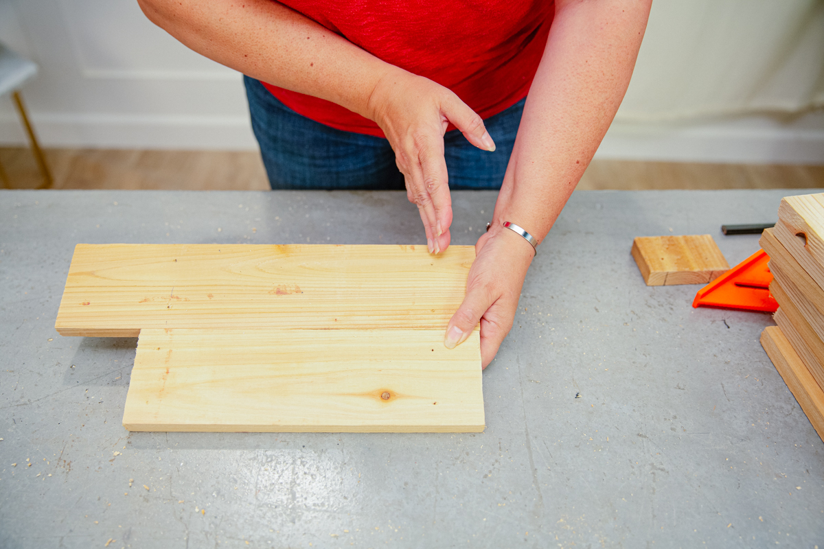 Holding boards of different lengths against each other.