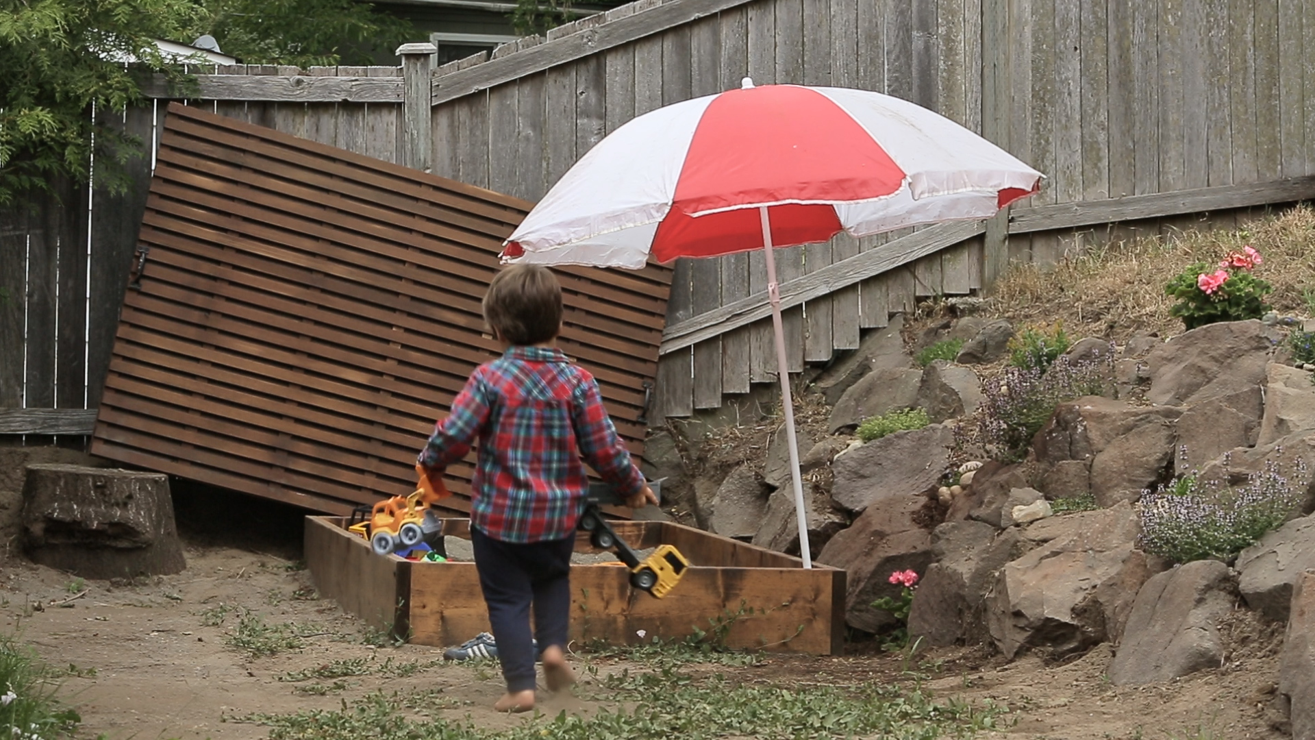 Child playing in wood DIY sandbox, which is stained with Perofin Verde Bitterwood.