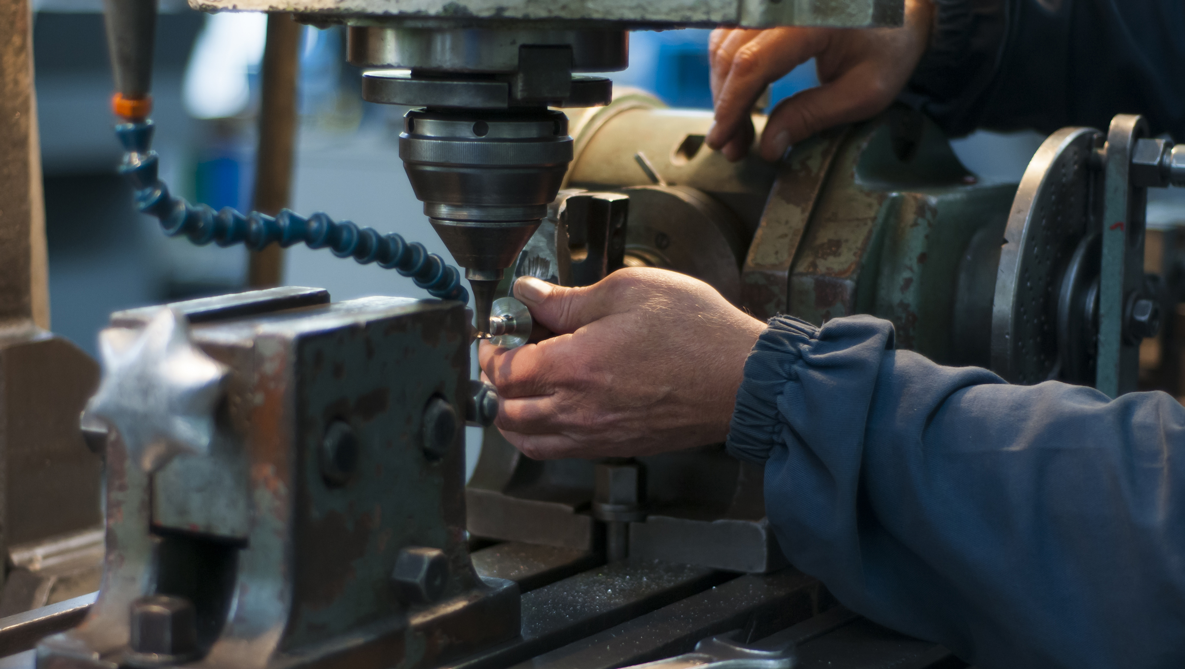 A machinist at work behind a specialized tool.