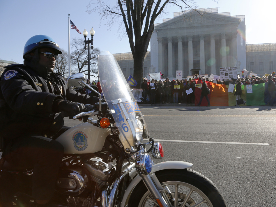 A Washington D.C. motorcycle police officer kept watch on demonstrators outside the Supreme Court Tuesday morning. Jonathan Ernst /Reuters /Landov A Washington D.C. motorcycle police officer kept watch on demonstrators outside the Supreme Court Tuesday morning. Jonathan Ernst /Reuters /Landov