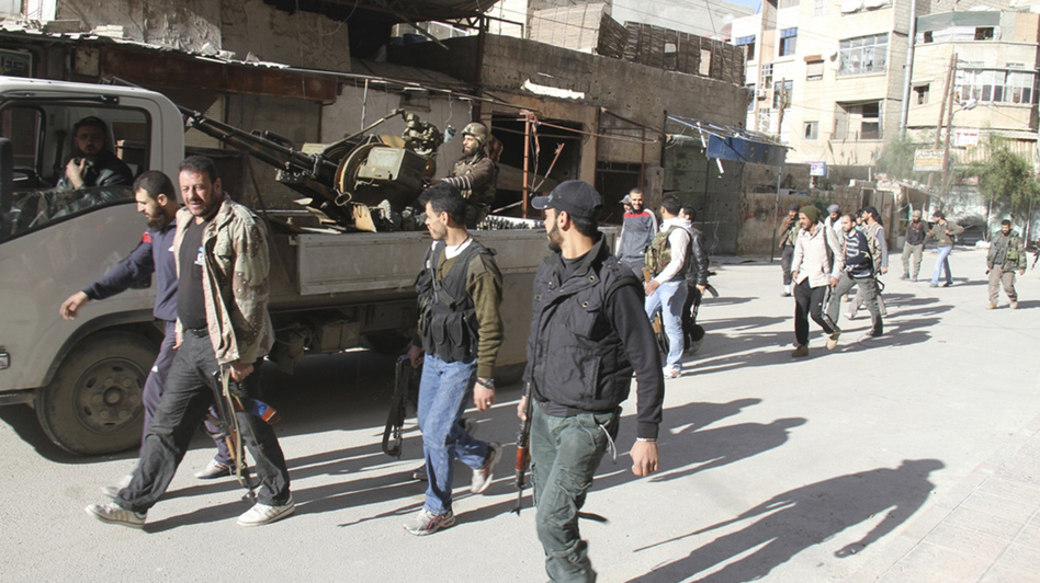 Rebels from the Free Syrian Army walk on a street in Damascus in this picture provided by Shaam News Network and taken March 23. Rebels from the Free Syrian Army walk on a street in Damascus in this picture provided by Shaam News Network and taken March 23.