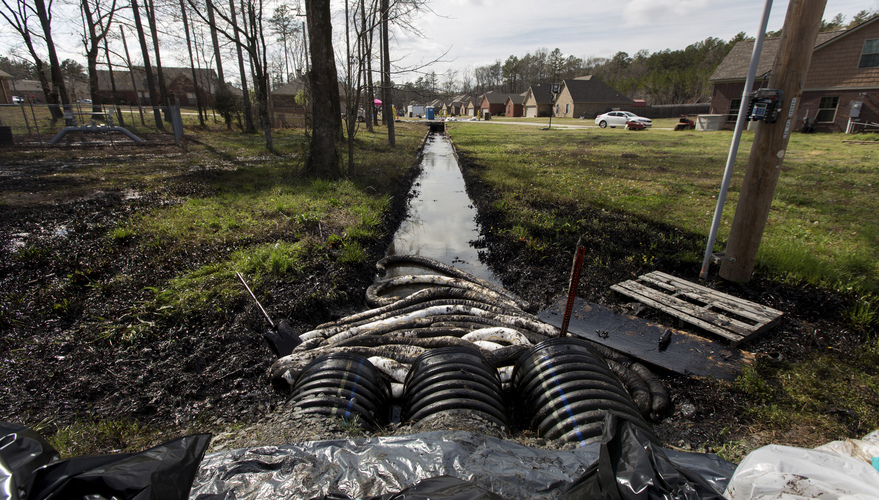 Spilled crude oil is seen in a drainage ditch near evacuated homes near Starlite Road in Mayflower, Ark., on March 31. An Exxon Mobil pipeline carrying Canadian crude oil was shut off after a ruptured on March 29, causing an evacuation of 22 homes. Jacob Slaton/Reuters/Landov Spilled crude oil is seen in a drainage ditch near evacuated homes near Starlite Road in Mayflower, Ark., on March 31. An Exxon Mobil pipeline carrying Canadian crude oil was shut off after a ruptured on March 29, causing an evacuation of 22 homes. Jacob Slaton/Reuters/Landov
