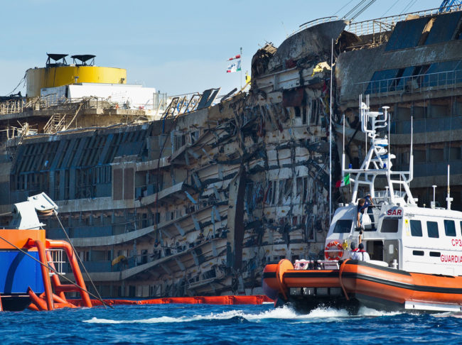 A Coast Guard patrols in front of the severely damaged right side of the Costa Concordia cruise ship after it was righted last week. Marco Secchi/Getty Images A Coast Guard patrols in front of the severely damaged right side of the Costa Concordia cruise ship after it was righted last week. Marco Secchi/Getty Images