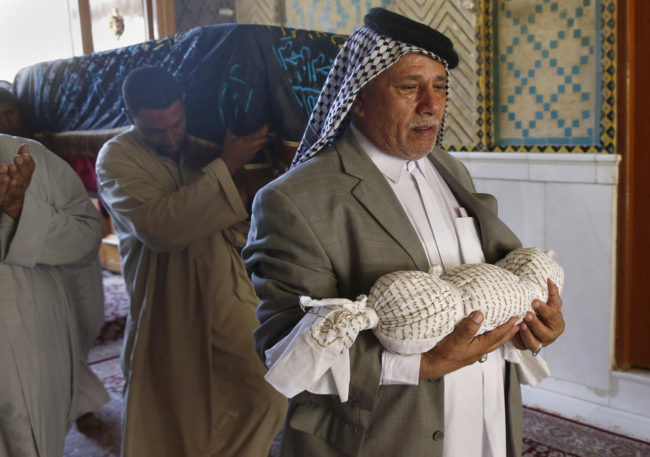 Mahmoud Abdel Rahman carries the dead body of his eleven-month old grandson, Latif, who was killed along with his mother on Monday when their house collapsed in a car bomb attack, while mourners carry the coffin of the mother, Hasnah Abdel Rasul, during their funeral in the Shiite holy city of Najaf, on Tuesday. Jaber al-Helo/AP Mahmoud Abdel Rahman carries the dead body of his eleven-month old grandson, Latif, who was killed along with his mother on Monday when their house collapsed in a car bomb attack, while mourners carry the coffin of the mother, Hasnah Abdel Rasul, during their funeral in the Shiite holy city of Najaf, on Tuesday. Jaber al-Helo/AP
