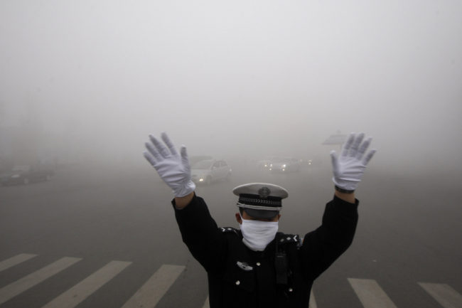 A policeman gestures as he works on a street in heavy smog in Harbin, northeast China's Heilongjiang province, on Monday. AFP/AFP/Getty Images A policeman gestures as he works on a street in heavy smog in Harbin, northeast China's Heilongjiang province, on Monday. AFP/AFP/Getty Images