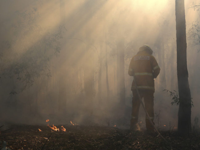 Flames flicker near Bilpin, Australia, as a firefighter finishes securing the area on Wednesday. Rob Griffith/AP Flames flicker near Bilpin, Australia, as a firefighter finishes securing the area on Wednesday. Rob Griffith/AP