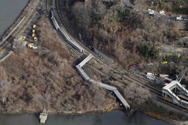 A Metro-North passenger train derailed in the Bronx borough of New York on Sunday, coming to a rest just feet from the water. Authorities say four people were killed and 63 injured. Mark Lennihan/AP A Metro-North passenger train derailed in the Bronx borough of New York on Sunday, coming to a rest just feet from the water. Authorities say four people were killed and 63 injured. Mark Lennihan/AP