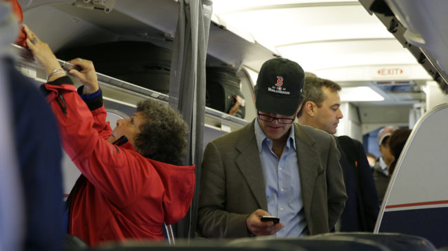 A passenger checks his cellphone while boarding a flight in Boston. The Federal Communications Commission is proposing new rules to allow using cellphones for data and voice calls during airline flights. Matt Slocum/AP A passenger checks his cellphone while boarding a flight in Boston. The Federal Communications Commission is proposing new rules to allow using cellphones for data and voice calls during airline flights. Matt Slocum/AP