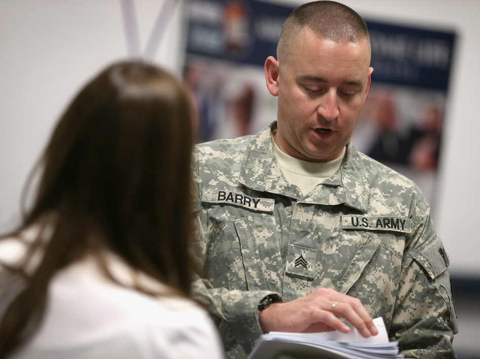 Sgt. Troy Barry (right), with the Army National guard, speaks with Katie Sogar with Rivers Casino during a job fair for veterans in September. Scott Olson/Getty Images