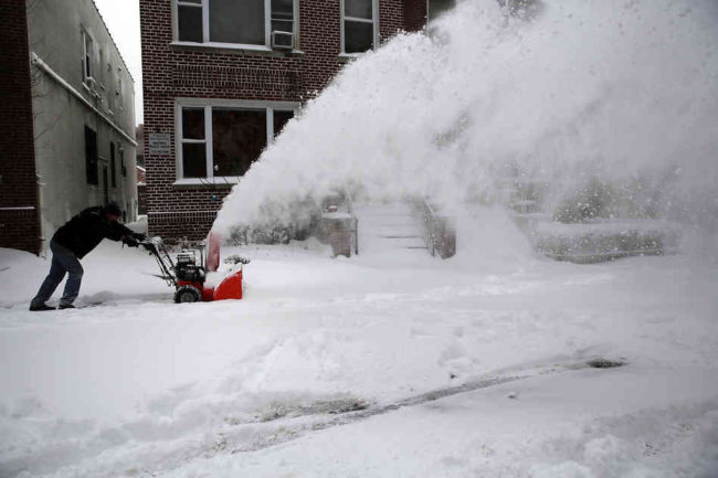A man clears snow from a sidewalk in Brooklyn following a snow storm that left up to seven inches of snow on Friday. A major snowstorm producing blizzard-like conditions brought bone-chilling temperatures and high winds to the Northeast, with nearly 2 feet of snow falling in some areas of Massachusetts. (Spencer Platt/Getty Images)