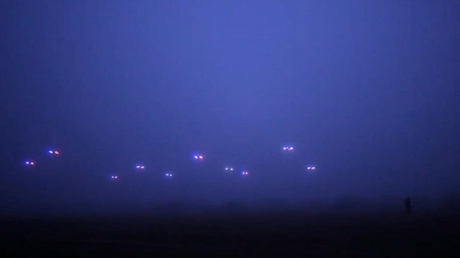 An image from a video by the COLLMOT Robotic Research Project shows a group of drones flying autonomously across a field. COLLMOT Robotic Research Project