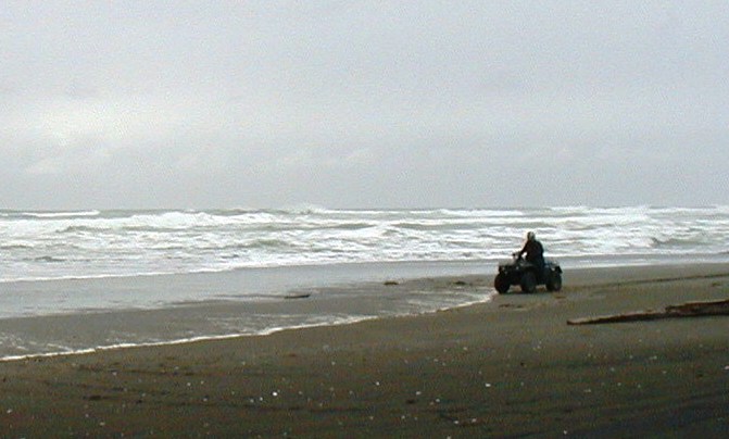 An ATVer rides along a Yakutat beach where a wave-energy system is to be installed. A Boston-based company will install the first device in 2015. (Ed Schoenfeld/CoastAlaska News)