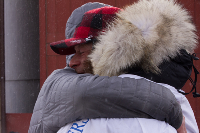 Martin Buser was greeted by hugs galore from friends and family, handlers and his Nome hosts.(Photo by KNOM Radio Mission)