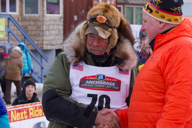Sonny Lindner receiving congratulations from Iditarod Trail Committee Executive Director Stan Hooley.(Photo by KNOM Radio Mission)