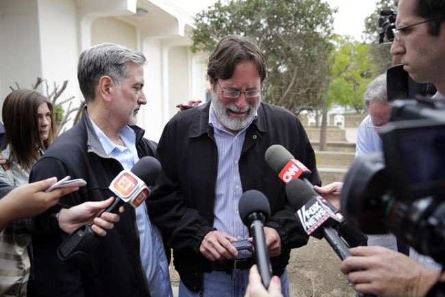 Richard Martinez (center), whose son Christopher was killed in Friday's attack, is comforted by his brother Alan. Jae C. Hong/AP