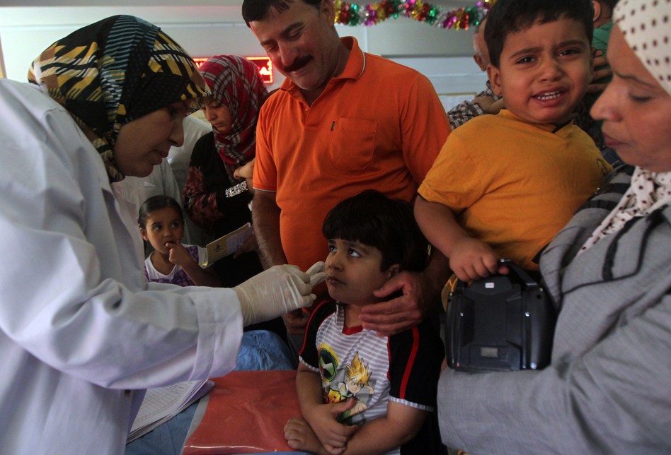 A doctor gives a polio vaccine to a child at a health clinic in Baghdad last week. The CIA says it banned the use of vaccine programs as cover for spying last year — a practice health officials said had wide repercussions. Ahmad Al-Rubaye/AFP/Getty Images