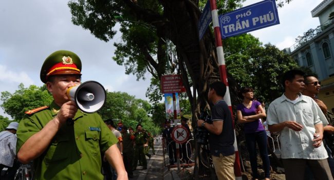 Policemen ask people to leave a street near to the Chinese embassy in Hanoi on Sunday. A call for further anti-China protests appeared to have fizzled in the capital, with authorities deploying heavy security around the Chinese embassy and other suspected protest sites. Hoang Dinh Nam /AFP/Getty Images