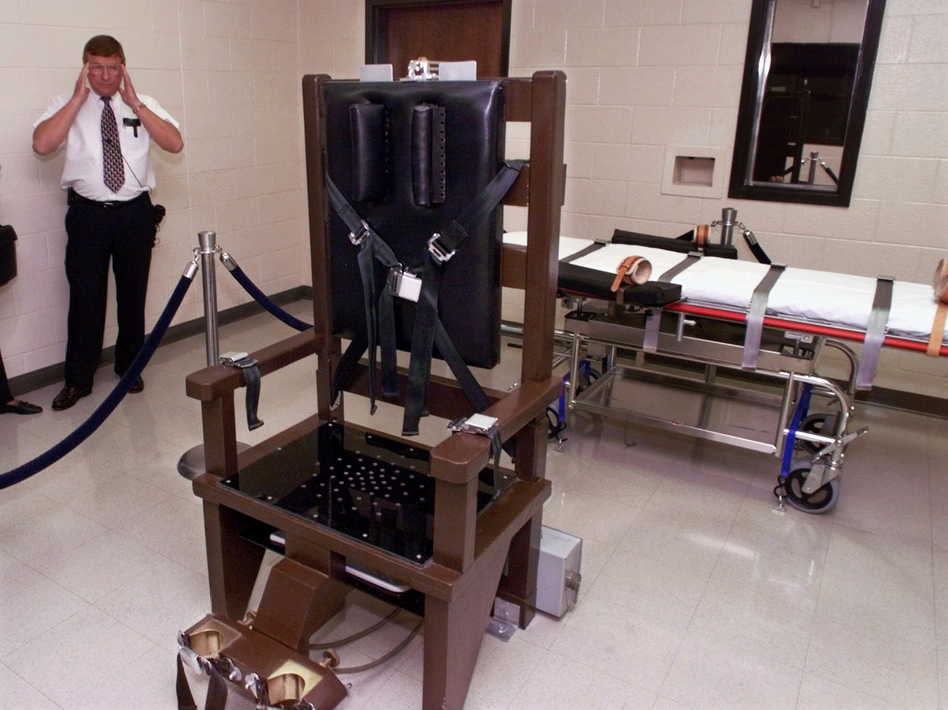 A warden at Riverbend Maximum Security Institution in Nashville, Tenn., is shown in the prison's execution chamber in 1999. The electric chair is shown next to a lethal injection gurney. Mark Humphrey/AP
