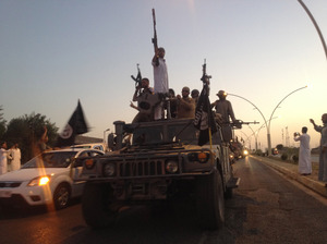 Fighters of the Islamic State of Iraq and Syria parade in a commandeered Iraqi security forces armored vehicle in Mosul, Iraq, on June 23. Human Rights Watch says the group executed at least 160 unarmed Iraqis after it took control of the city of Tikrit. AP