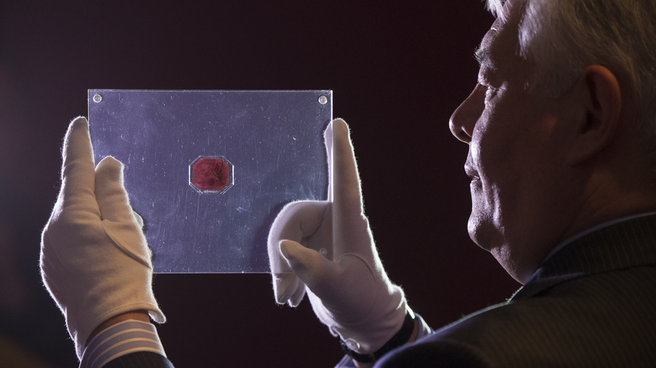 David Redden of Sotheby's auction house holds a case containing the sole-surviving "British Guiana One-Cent Black on Magenta" stamp dating from 1856. Oli Scarff/Getty Images