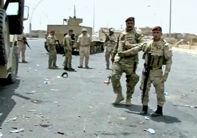 Armed Iraqi soldiers take their positions during clashes with militants in the northern city of Mosul, Iraq. Uncredited/AP