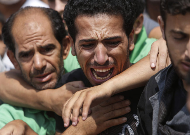 A relative bursts into tears in front of the bodies of seven members of the Kelani family, killed overnight by an Israeli strike in Gaza City. Lefteris Pitarakis/AP