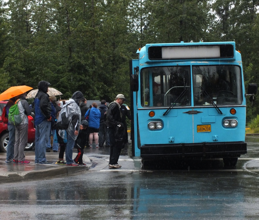 Passengers board a bus at the Mendenhall Glacier Visitor Center on Tuesday. (Photo by Matt Miller/KTOO)