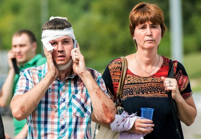 An injured man who was on a subway train that derailed Tuesday in Moscow talks on his phone after being treated by paramedics. Dmitry Serebryakov/AFP/Getty Images