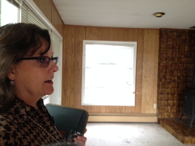 Jill Reese talks about the project inside one of the homes slated for removal. (Photo by Hillman/KSKA)