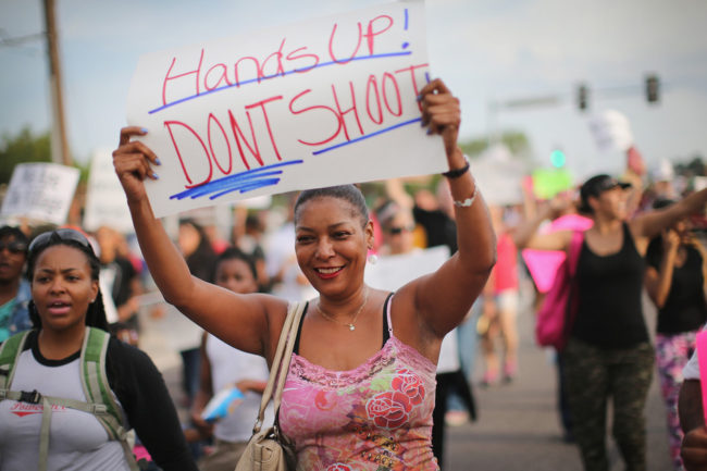 Protests against the police shooting and killing of teenager Michael Brown had a different feel Thursday in Ferguson, Mo. Police scaled back their military-style operations and instead walked with protesters. Scott Olson/Getty Images