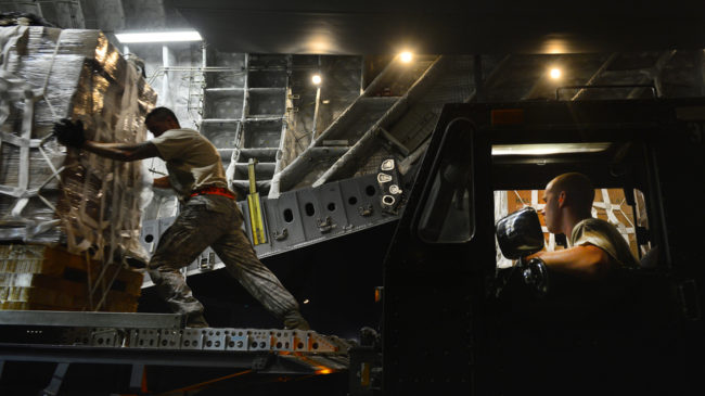 Staff Sgt. Daniel Leavindofske and Senior Airman David Babcock help load bundles of halal meals onto a cargo aircraft for a humanitarian mission over Iraq on Saturday. Staff Sgt. Vernon Young Jr./U.S. Air Force via Getty Images
