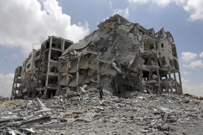 A Palestinian searches for salvageable items from the rubble of his house that was destroyed in Israeli strikes. Adel Hana/AP