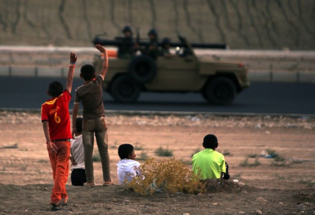 Iraqi children from the Yazidi community wave to Kurdish peshmerga forces near Dohuk, the Kurdish region of autonomous Kurdistan in Iraq. The children fled with their families from their hometown, which was attacked by Sunni militants from the Islamic State. Ahmad Al-Rubaye/AFP/Getty Images