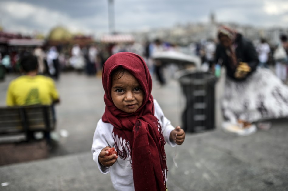 A Syrian refugee child eats food which her mother collected from rubbish at Eminonu in Istanbul. Bulent Kilic /AFP/Getty Images