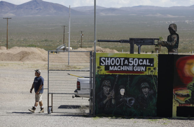 A man closes off an entrance to the Last Stop shooting range in White Hills, Ariz., on Wednesday. Instructor Charles Vacca was killed at the range Monday by a 9-year-old girl he was teaching to use an Uzi submachine gun. John Locher/AP