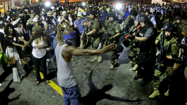 Police arrest a man as they disperse a protest Wednesday for Michael Brown, who was killed by police Aug. 9 in Ferguson, Mo. Charlie Riedel/AP
