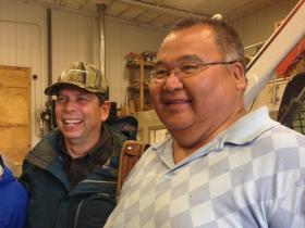 Sen. Mark Begich and Robert Andrews, head of a boat-building shop in Emmonak. Andrews told Begich, “You’re helping a little bit now and then. Sometimes you deny the CDQs, but sometimes you agree with them … If I vote for you, man, you better think of back here.” (Photo by Joaqlin Estus/KNBA.)