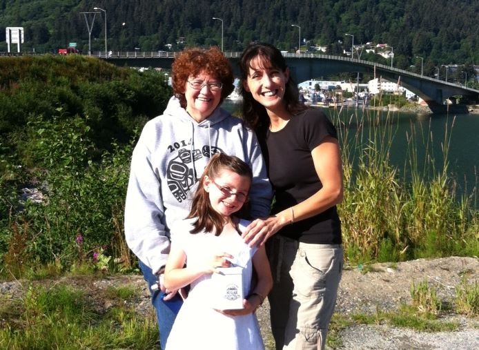 Sheila Short, mother of Amber Schneider, accepted the money from Ildi and Sophia Nylen on Saturday. Sophia, Juneau's youngest busker, gave the $1,562 in cash and two gift certificates in a cookie jar. (Photo courtesy of Ildi Nylen)